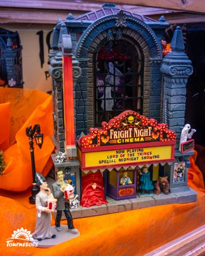 Maquette Lemax d'un cinéma Halloween avec des figurines devant.